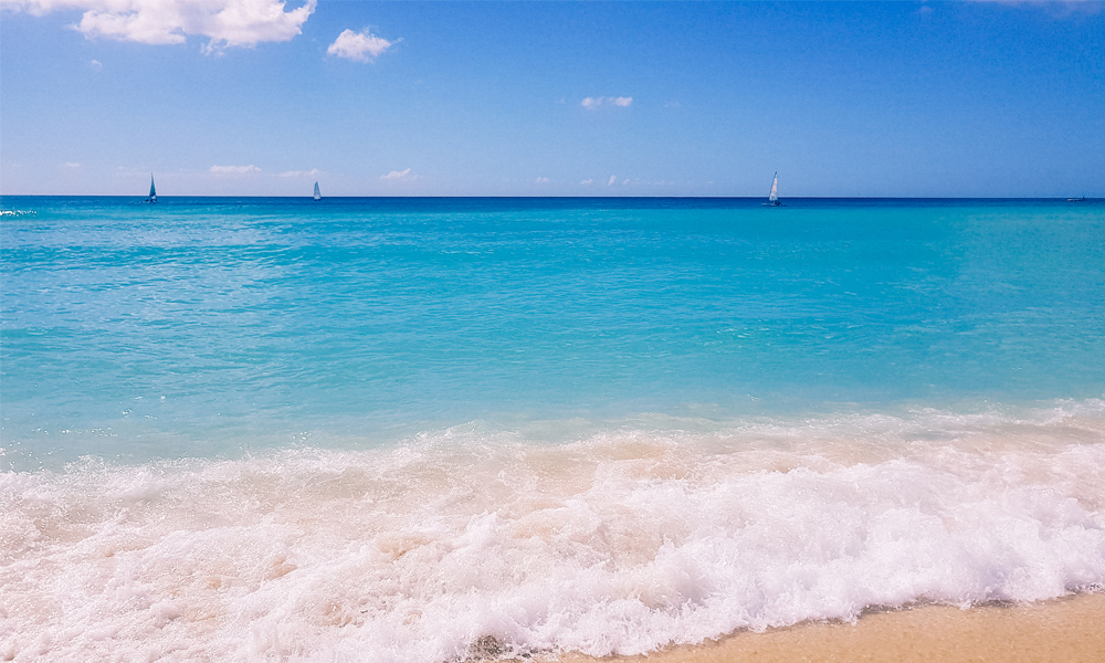 alt="Blue seat water at the shore at Bayahibe beach"