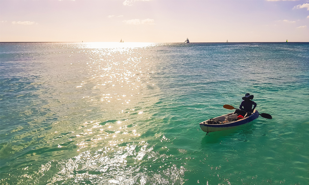 alt="Fisherman in the middle of the sea on a small boat at Bayahibe beach"