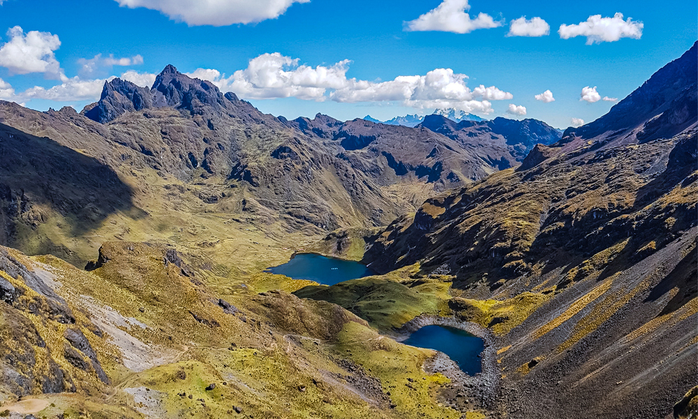 alt="Lares trek hike in the Andes mountains walking up to two blue lakes in Peru"