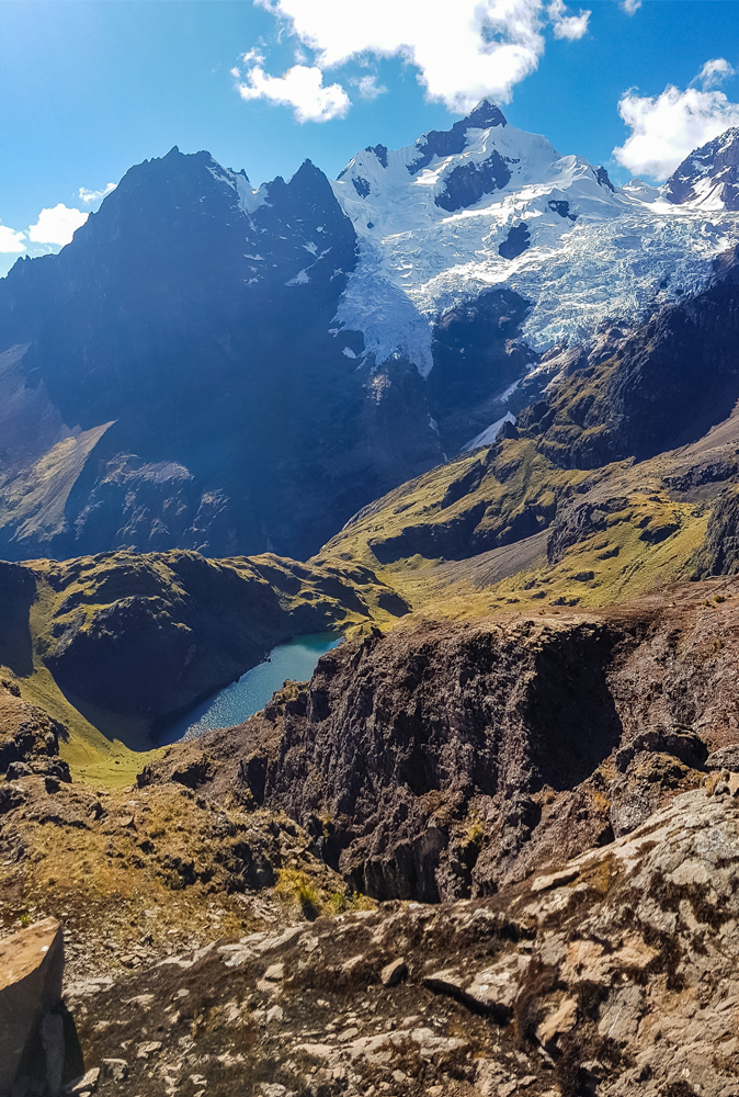 alt="Lares Trek hike among snowy mountains and blue lake in Peru"