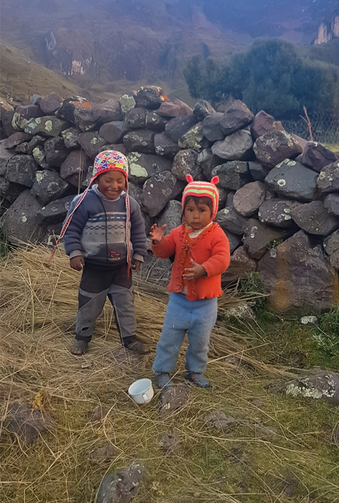alt="Local Quechuan children playing on the mountains in Peru"