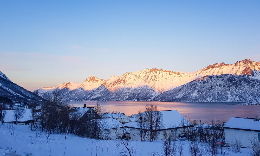 alt=“Pink sunset over snowy mountains in Northern Norway”