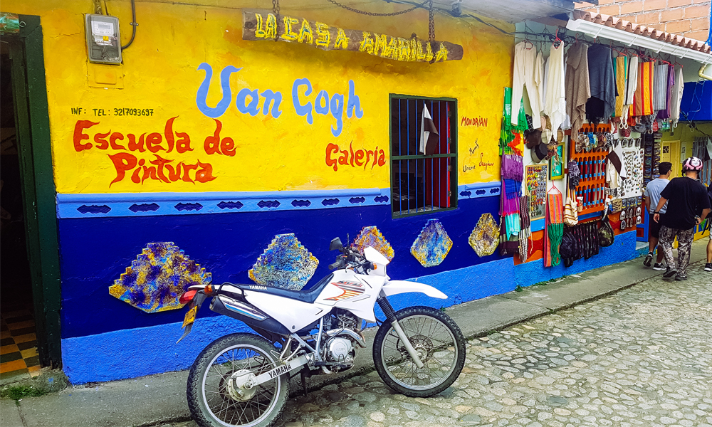 alt="Colourful Van Gogh gallery with motorbike parked outside in Guatape, Colombia"