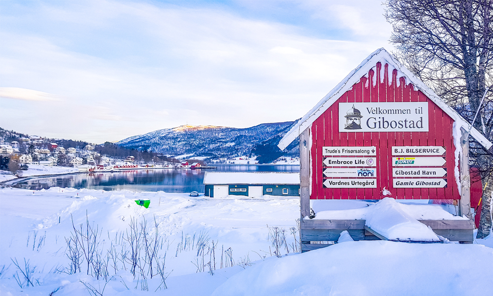 alt=“Red sign saying Welcome to Gibostad written in Norwegian, Northern Norway”