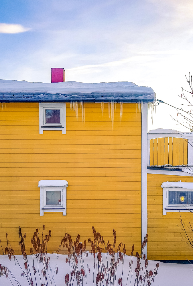 alt=“Yellow painted house with icicles in Gibostad town, Northern Norway”