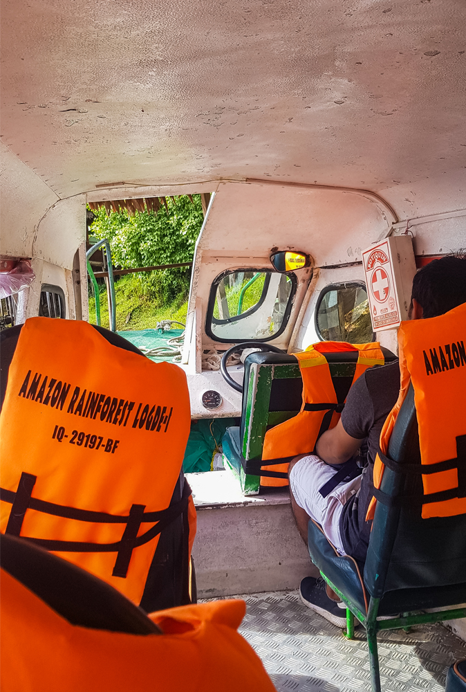 alt=“Amazon Rainforest Lodge boat transport with branded orange lifejackets”