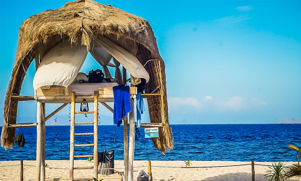 alt="Le Pirate Island private island beach hut with straw roof and with sea view"