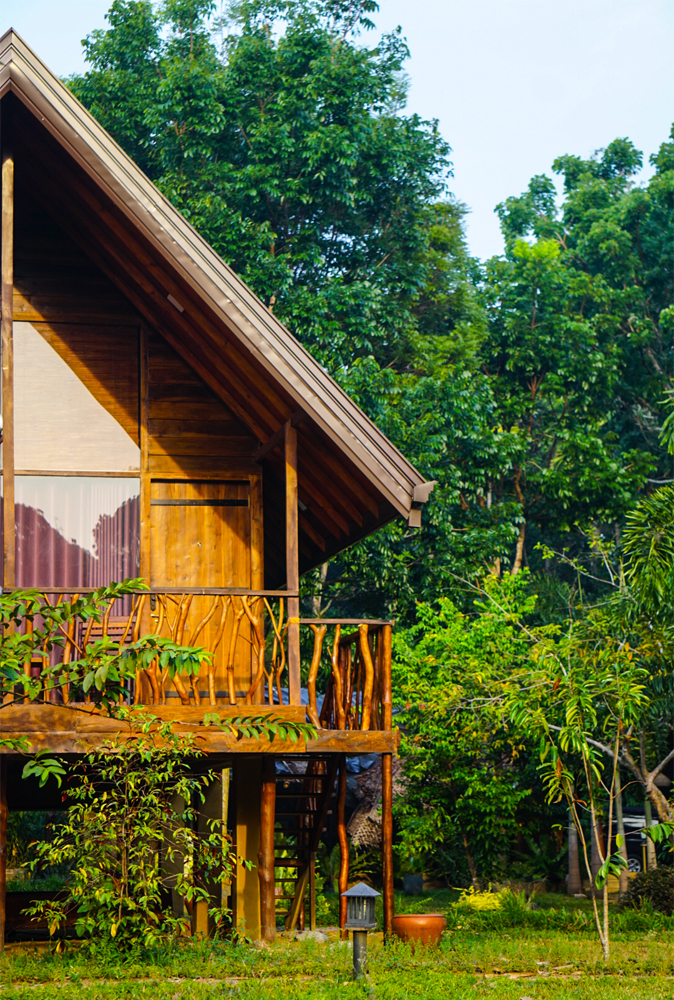 alt=“Kandy cabana with wooden hut with trees in the background”