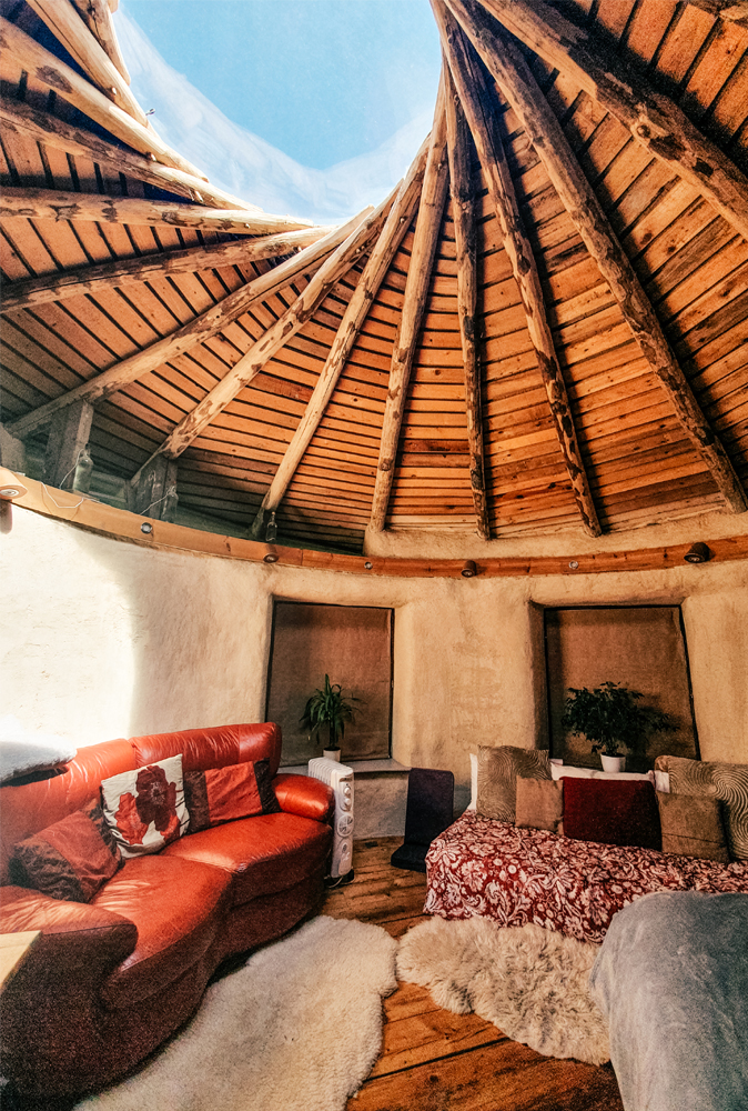 alt=“straw-house-canterbury-ceiling-red-sofa”