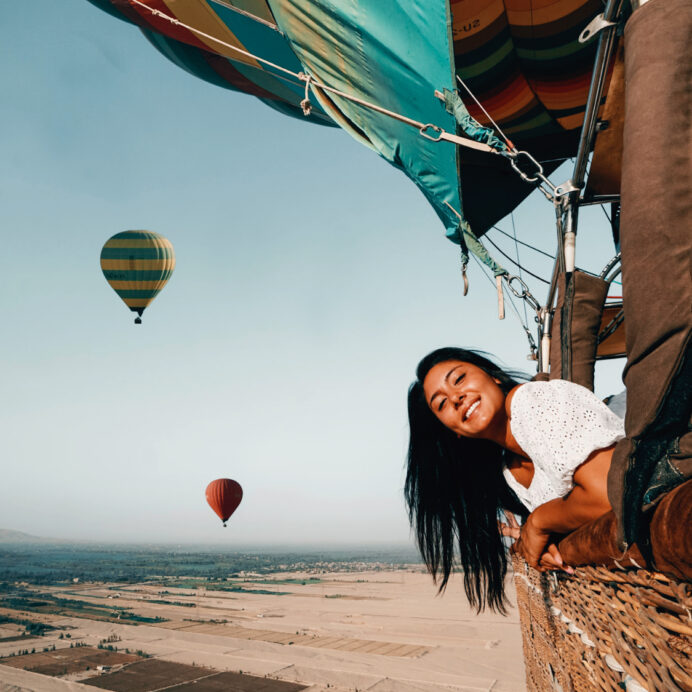 alt="paper pelicans girl smiling with hot air balloons in the background"